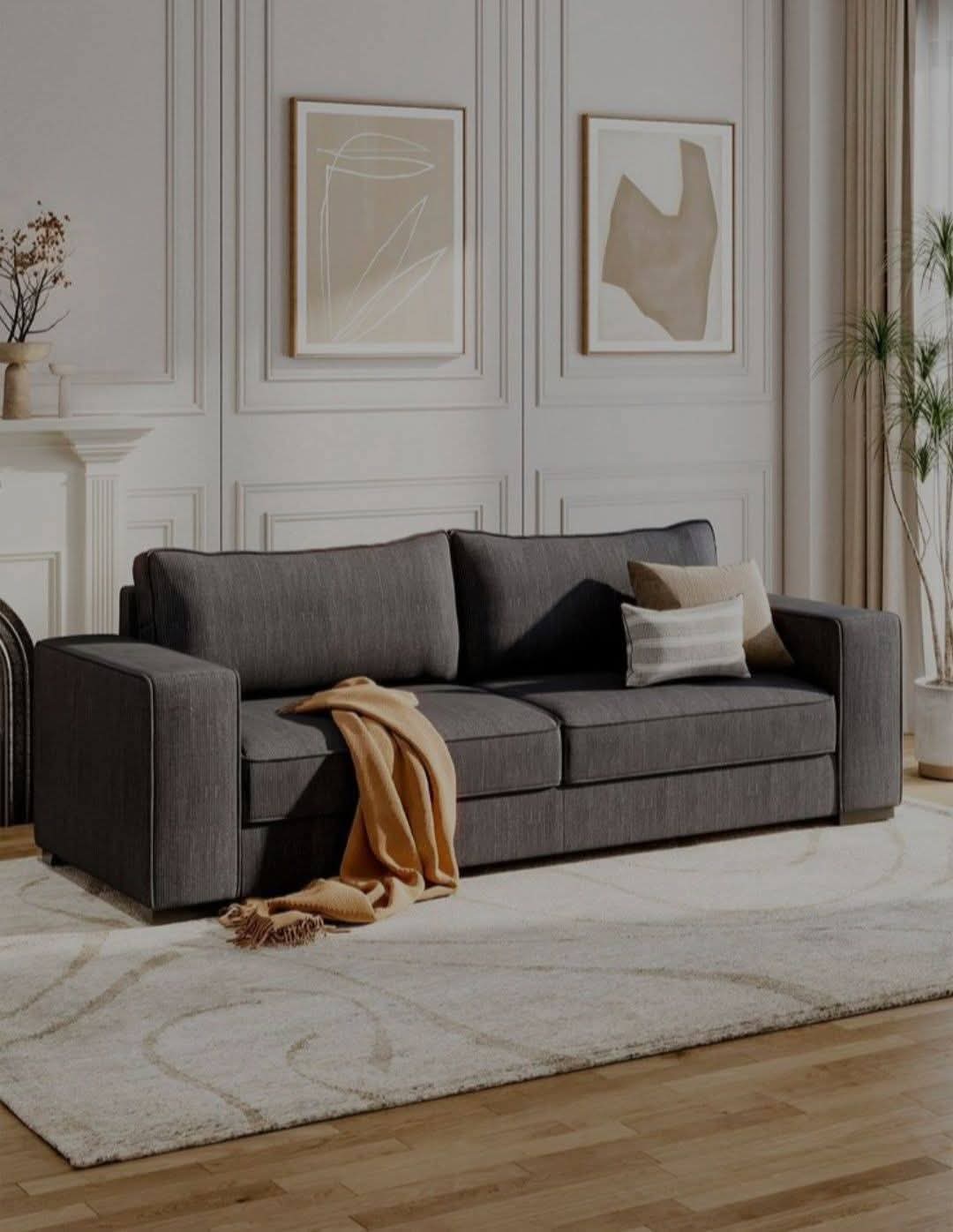 Charcoal linen three-seater sofa with structured arms and deep cushioning in a classic white panelled living room